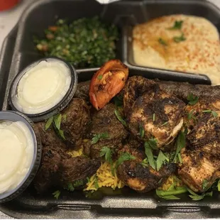 Mixed Kebab Platter: Ribeye Beef, Chicken and Kafta marinated in garlic, herbs and spices served with hummus, yellow rice, tabbouleh.