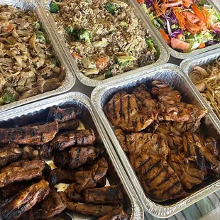 Our catering order. Top: pad see ew with beef, fried rice, salad. Bottom: grilled ribs, grilled chicken, garlic noodles with shrimp