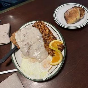 Chicken Fried Steak with sausage gravy, hash browns, two eggs over medium and an English muffin