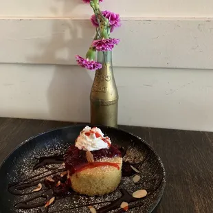 a dessert on a plate with a vase of flowers in the background