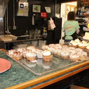 a woman in the kitchen preparing cupcakes