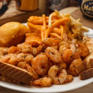 a plate of food with shrimp, french fries, and bread