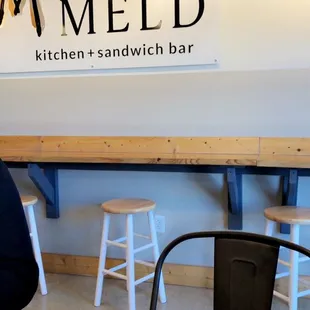 a woman standing in front of a sandwich bar