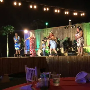 Dancer teaching audience members how to dance hula
