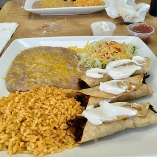 Taquitos with roast beef, rice and refried beans!!! Made by our waiter!