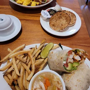 Breakfast bowl with scrambled eggs (top) and Buffalo chicken wrap with fries and chicken noodle soup (bottom)