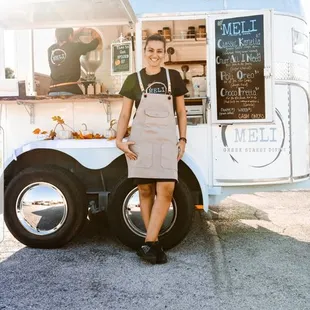 a woman standing in front of a food truck