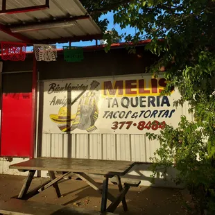 a picnic table in front of a restaurant
