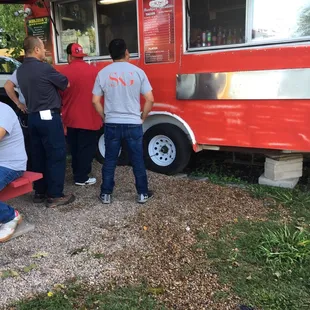 a group of people standing in front of a food truck
