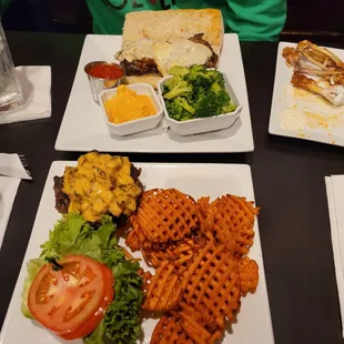 a plate of waffles, a sandwich, and a salad