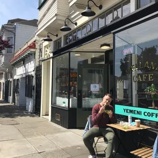 a man sitting at a table outside