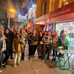 a group of people standing on the sidewalk