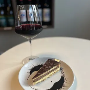 a piece of cake and a glass of wine