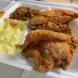 Chicken with potato salad and baked beans.