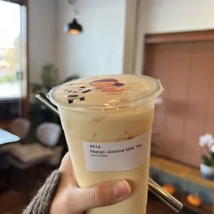 a hand holding a cup of boba