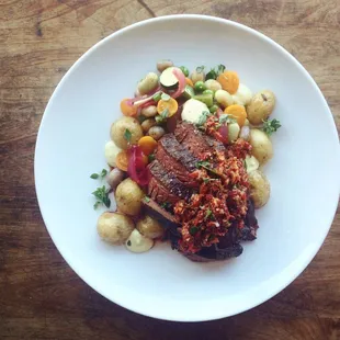 NY strip with romesco sauce new potatoes, hand shucked peas, sherry roasted red onion, gigante white beans and sungold tomatoes