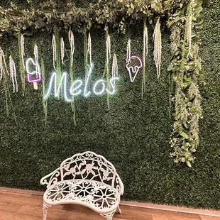 a white chair in front of a green wall