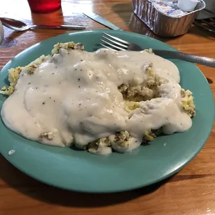 Lil scrambler, 2 eggs, sausage, hash browns on top of a biscuit smothered with gavy