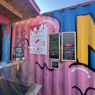 a pink and blue food truck with menus on it