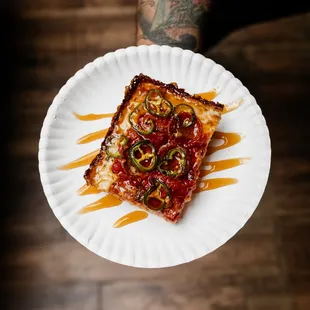 a piece of pizza on a paper plate