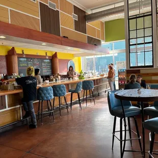 a view of a restaurant with people sitting at the bar