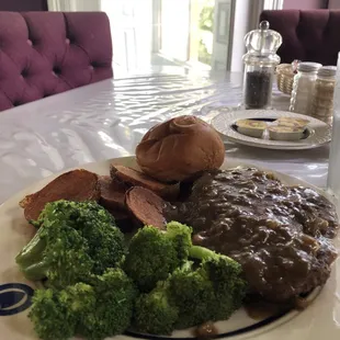 Hamburger steak with steamed veggies and potatoes.