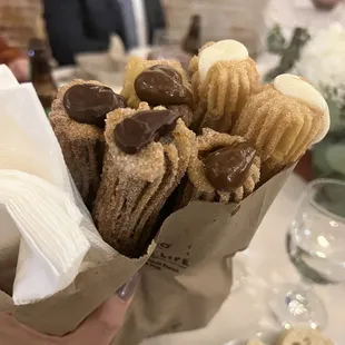 a person holding a bag of churros