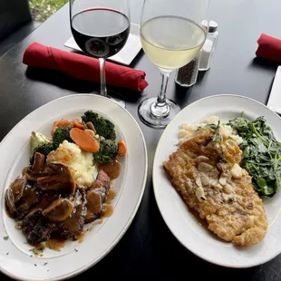  two plates of food and a glass of wine