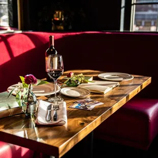 a table set for two with a wine bottle and glasses