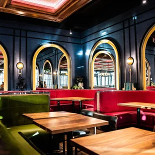 a brightly lit restaurant with green and red booths