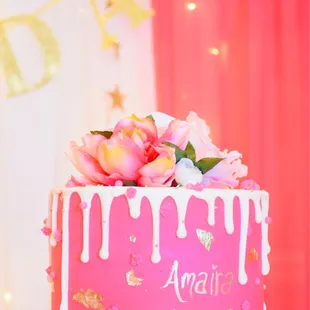 a pink cake decorated with flowers