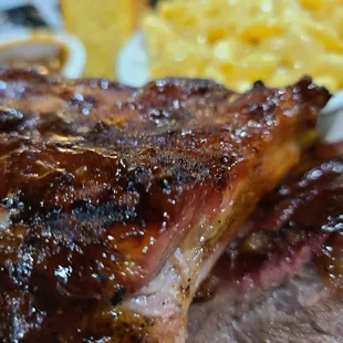 a plate of ribs and macaroni and cheese