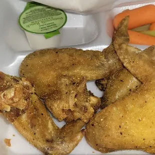 fried chicken and vegetables in a styrofoam container