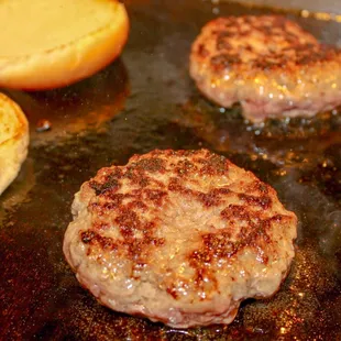 hamburgers cooking in a pan
