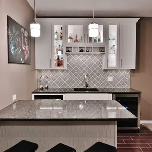 &quot;Lunar Eclipse&quot; Quartz counters and custom cabinets with glass fronts and built-in wine bottle shelf.