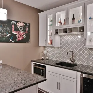 &quot;Lunar Eclipse&quot; Quartz counters and custom cabinets with glass fronts and built-in wine bottle shelf.