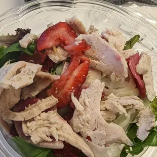 a salad with strawberries and chicken