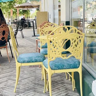 a row of yellow chairs on a sidewalk