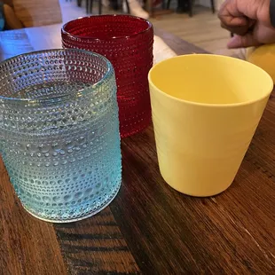 three different colored cups on a table