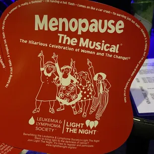 a fan with the logo of menopause the musical
