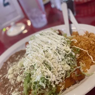 Chicken enchiladas with red sauce, rice and beans