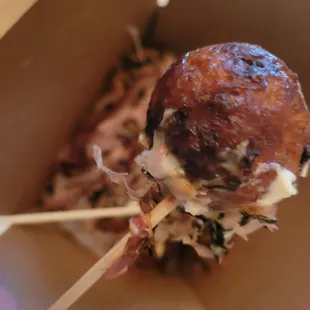 a meatball with cheese on a stick