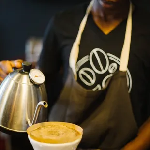 a man pouring a cup of coffee