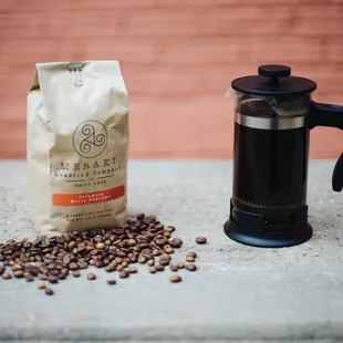a bag of coffee next to a coffee maker