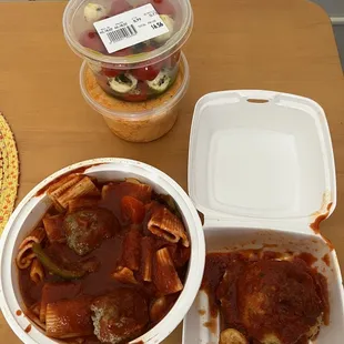 a bowl of pasta and a container of meatballs