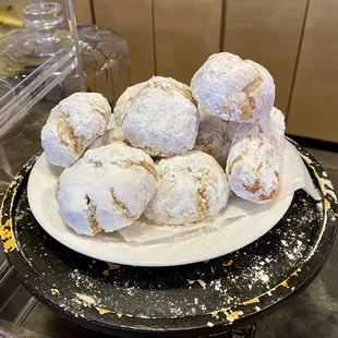 a plate of powdered sugared donuts