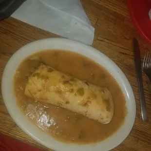 Egg and potatoe breakfast burrito smothered in extra hot green chili!