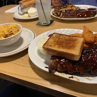a plate of ribs, french toast, macaroni and cheese