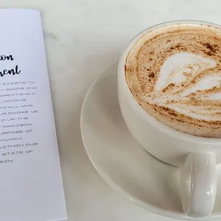 a cup of cappuccino and a menu