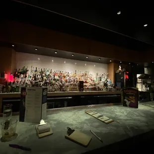 a bar with bottles of alcohol on the counter